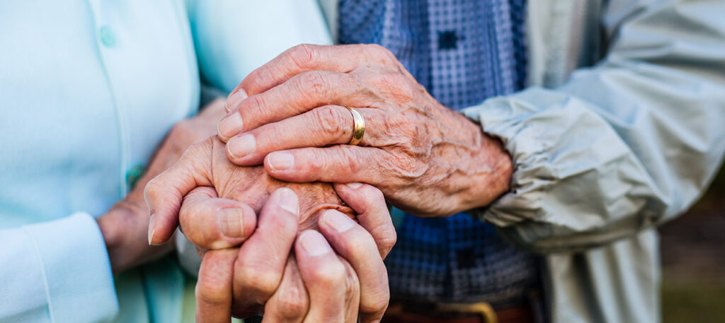 elderly couple holding hands wearing wedding bands; Broward County Florida Remarriage Protection Lawyer concept image